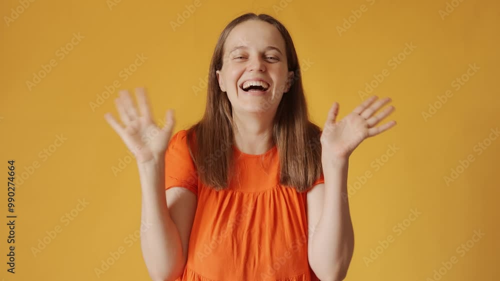 Cheerful woman with brown hair wearing orange shirt greeting with wave and big smile expressing happiness and friendliness welcomes everyone isolated over yellow background Cheerful woman with brown hair wearing orange shirt greeting with wave and big smile expressing happiness and friendliness welcomes everyone isolated over yellow background