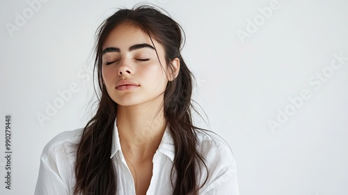 Woman with eyes closed in white shirt. Great for beauty, relaxation, or mindfulness themes.