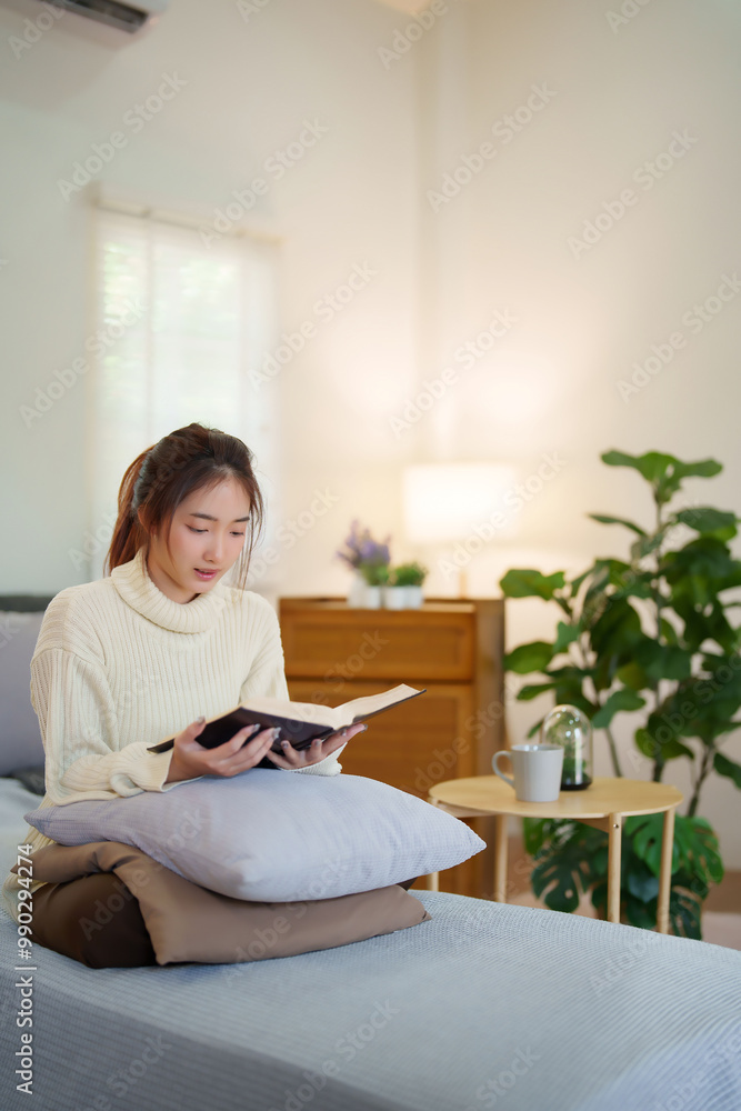Young asian women in sweater sitting on comfortable couch to enjoying and happiness with reading literature book while relaxation and doing activity to spending time with slow life lifestyle at home Young asian women in sweater sitting on comfortable couch to enjoying and happiness with reading literature book while relaxation and doing activity to spending time with slow life lifestyle at home