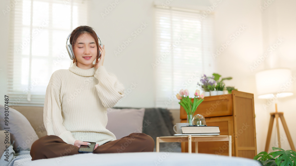 Young asian women in sweater wear headphone and close eyes to listening music with happiness while sitting on couch to relaxation and doing activity for spending time with slow life lifestyle at home Young asian women in sweater wear headphone and close eyes to listening music with happiness while sitting on couch to relaxation and doing activity for spending time with slow life lifestyle at home