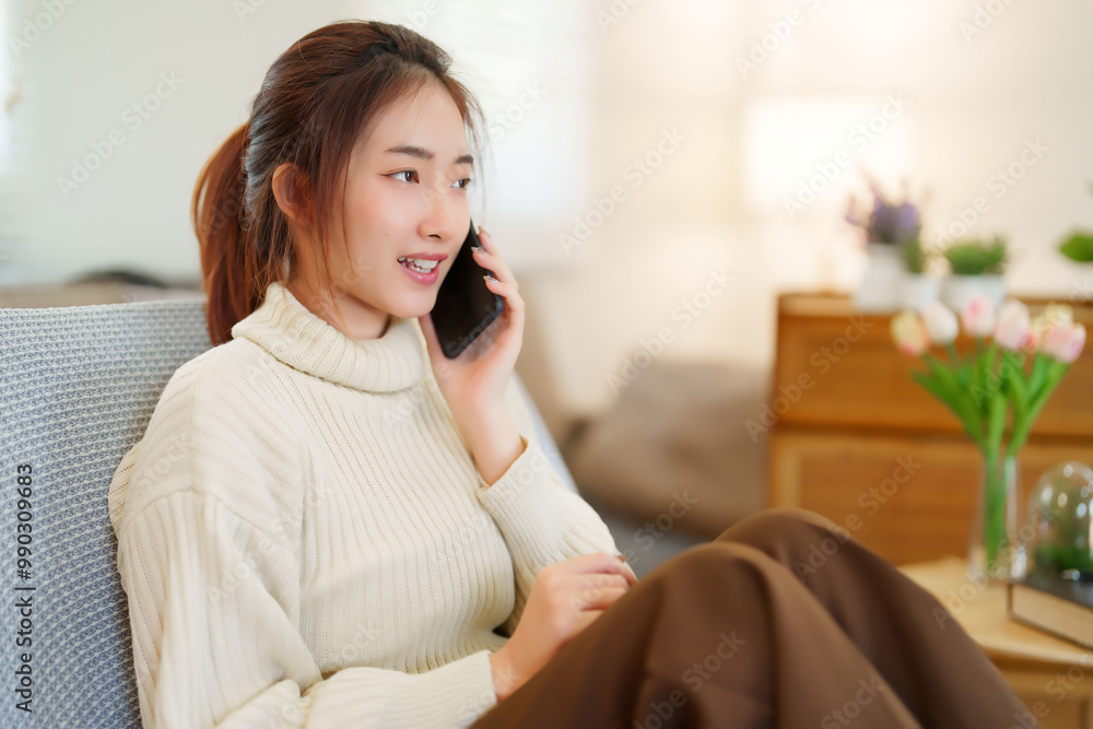 Young asian women in sweater using smartphone to talking and meeting for communication while sitting on the couch to relaxation and doing activity for spending time with slow life lifestyle at home Young asian women in sweater using smartphone to talking and meeting for communication while sitting on the couch to relaxation and doing activity for spending time with slow life lifestyle at home