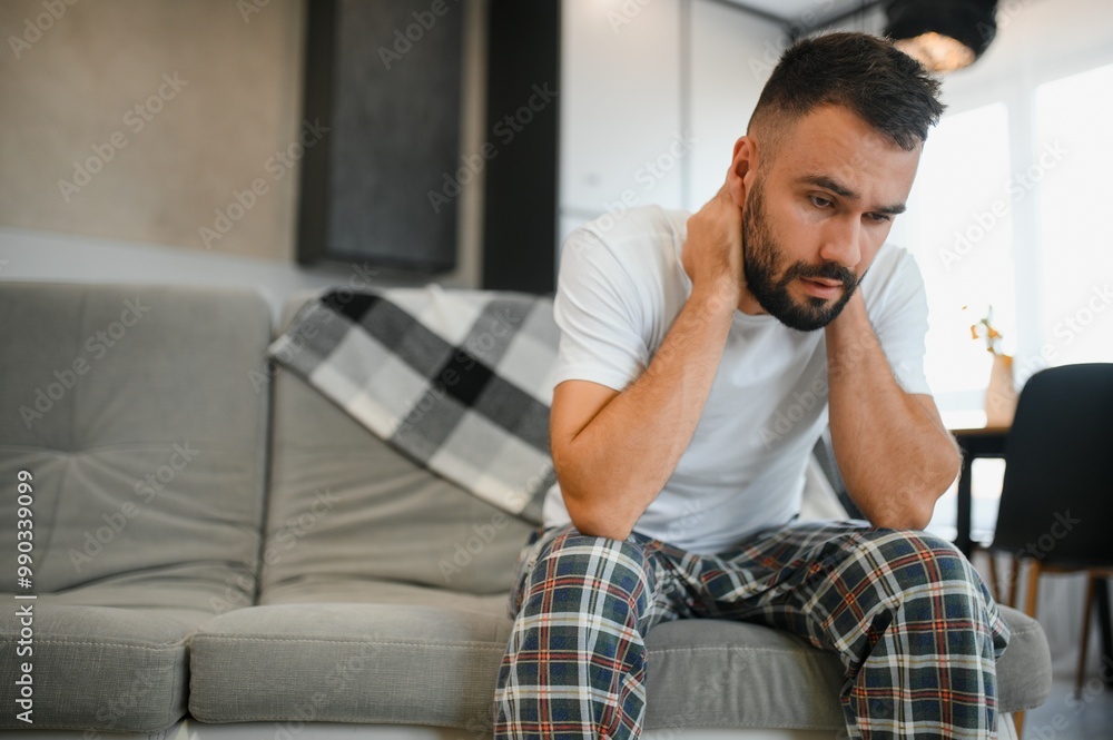 Obraz premium Sad man suffering from headache at home