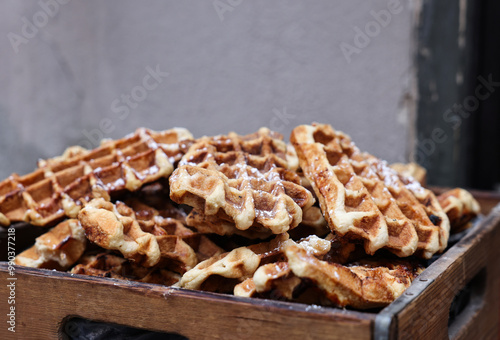 a stack of waffles sprinkled with powdered sugar