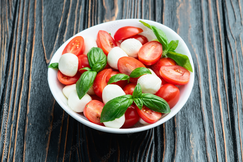 Basil leaves , cherry tomatoes and mozzarella cheese . In bowl food photography Basil leaves , cherry tomatoes and mozzarella cheese . In bowl food photography