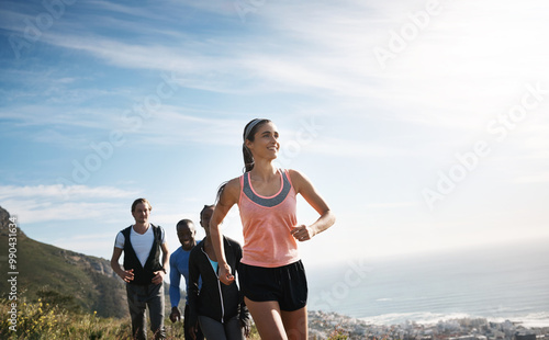 People, running and together with happiness on mountain or hill for support, diversity or exercise. Group, freedom and excited in workout, health club or sport team for outdoor adventure or training