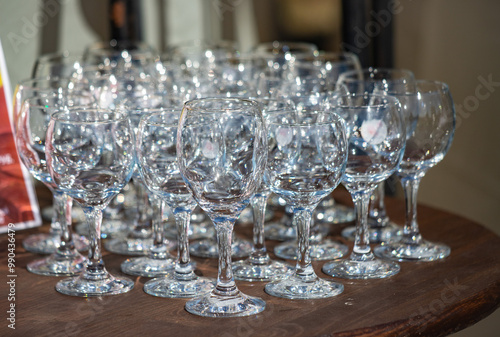 A wine glass is sitting on a wooden table photo