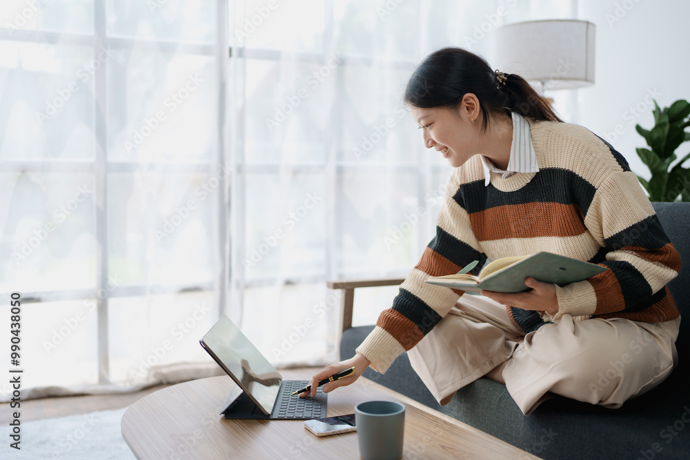 A woman sits on a sofa, using her notebook and tablet computer simultaneously to study online, efficiently managing her learning through digital platforms from the comfort of her home A woman sits on a sofa, using her notebook and tablet computer simultaneously to study online, efficiently managing her learning through digital platforms from the comfort of her home