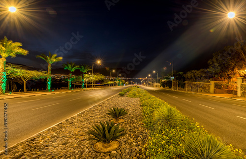 Twilight with street lamps on a wide avenue leading to the Red Sea, Middle East