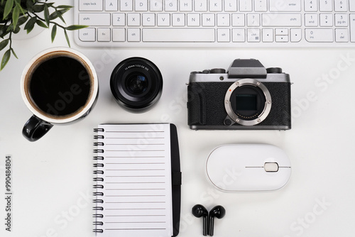 keyboard with camera and lenses, with earphone, mug of coffee, notebook, computer mouse and plant on white background