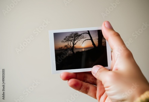 A Hand Holding a Photograph A person holding a photograph with t photo