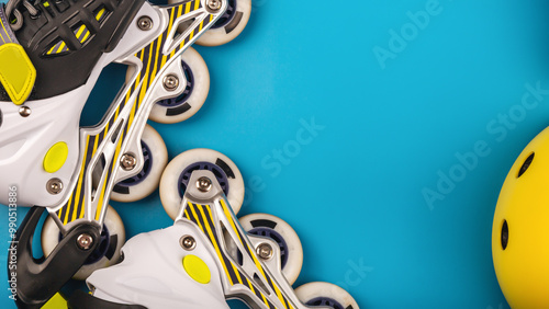 Top view of roller skates protective gear set - helmet and knee pads in black colors. blue background flat lay