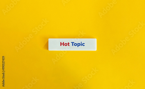 Hot Topic Phrase. Red and Blue Text on Block Letter Tile on Yellow Background. Minimal Aesthetic. photo