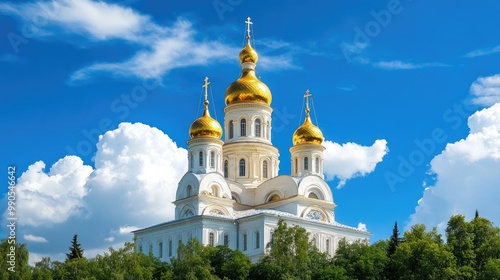 A breathtaking view of Nikolai Orthodox Church with golden domes under a clear blue sky, surrounded by lush greenery and vibrant flowers