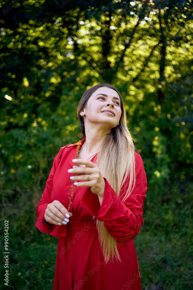 portrait of a beautiful 30-year-old woman with long blond hair in a red dress in a park portrait of a beautiful 30-year-old woman with long blond hair in a red dress in a park