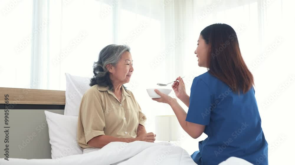 Sick elderly woman is closely cared for female nurse who is taking care of her. She slowly scoops porridge into her mouth nutritious cooked breakfast. Help her recover from her illness in bed at home. Sick elderly woman is closely cared for female nurse who is taking care of her. She slowly scoops porridge into her mouth nutritious cooked breakfast. Help her recover from her illness in bed at home.