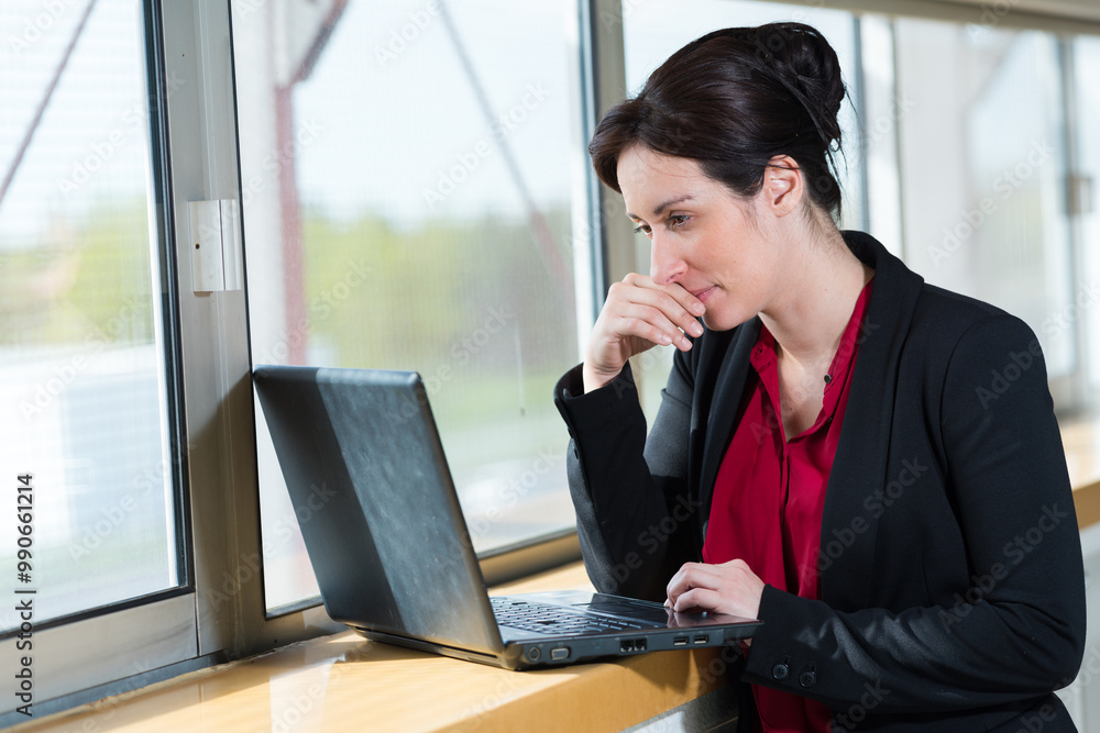 woman in office outfit looking at her laptop woman in office outfit looking at her laptop