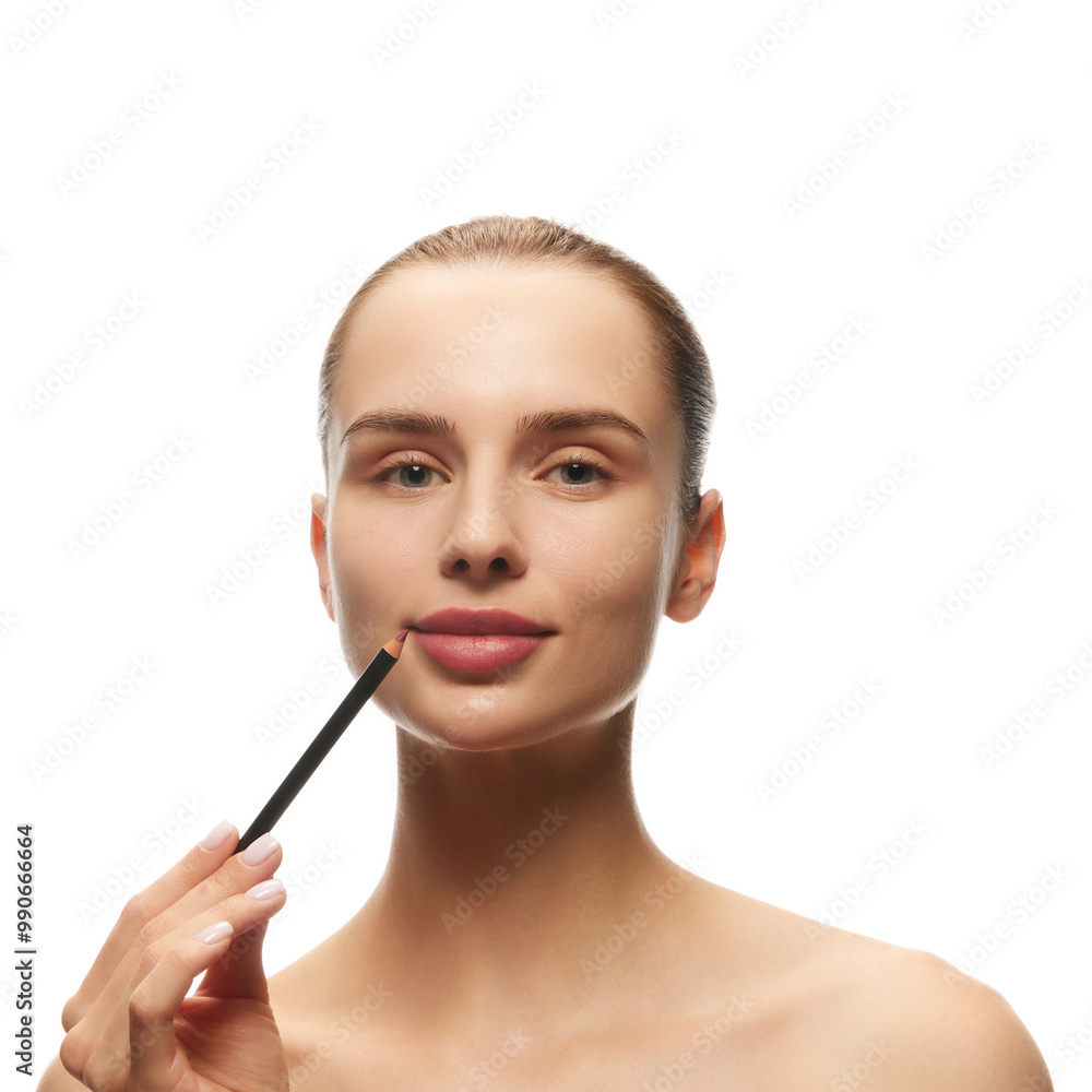 Portrait of beautiful young woman with clear, perfect, spotless skin, using lip pencil for nude makeup isolated on white background. Natural female beauty, skin care, cosmetics and cosmetology concept Portrait of beautiful young woman with clear, perfect, spotless skin, using lip pencil for nude makeup isolated on white background. Natural female beauty, skin care, cosmetics and cosmetology concept