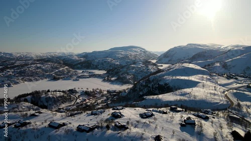 Aerial Drone Shot of Snow-Covered Winter Mountains and Cabins in Sinnes, Sirdal, Agder, Norway photo