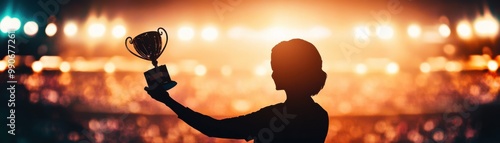 A silhouette of a person holding a trophy under bright stadium lights, symbolizing victory and achievement in sports.