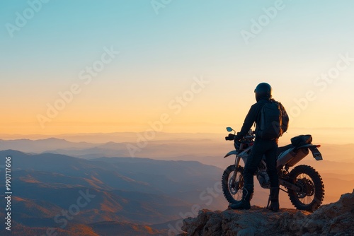 Adventurer enjoying sunset vistas while standing beside a motorcycle atop a mountain peak in a remote landscape photo