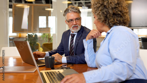 Mature businessman and his female colleague working together at the company office