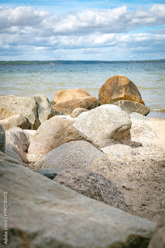 rocks on the beach in denmark with the horizon and sea as background photo