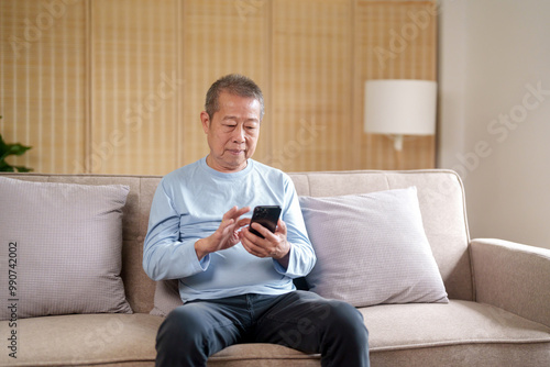 Asian senior elderly old man using mobile phone .