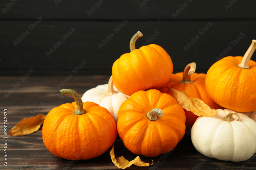 Festive autumn decor from pumpkins and leaves on black wooden background. Concept of Thanksgiving day or Halloween. Festive autumn decor from pumpkins and leaves on black wooden background. Concept of Thanksgiving day or Halloween.