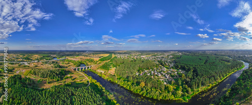 aerial panorama landscape summer bright weather day time country side rustic environment space of village with river bridge across water and people settlement