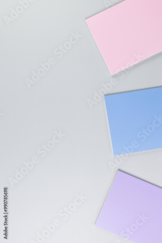 Top view of pink, purple and blue notebooks on grey background. School, office wallpaper. Flat lay, copy space.