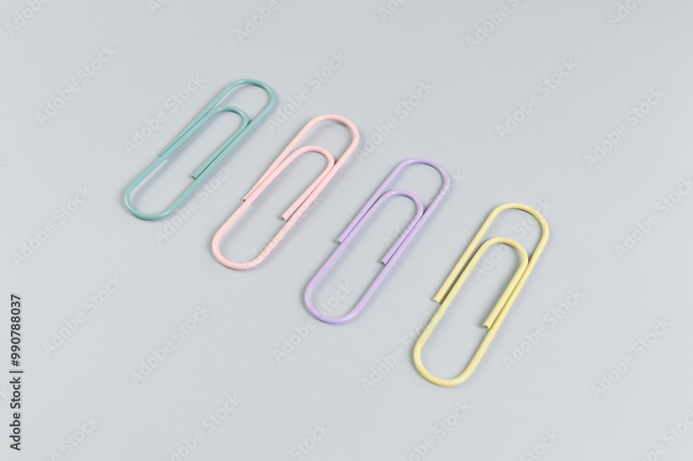 Top view of colorful paperclips on grey background. School, office wallpaper. Flat lay, copy space. Top view of colorful paperclips on grey background. School, office wallpaper. Flat lay, copy space.
