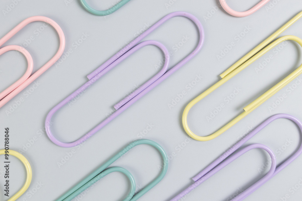 Top view of colorful paperclips on grey background. School, office wallpaper. Flat lay, copy space. Top view of colorful paperclips on grey background. School, office wallpaper. Flat lay, copy space.