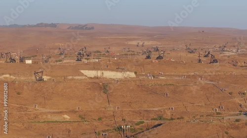 Aerial view of the oil rigs and wells in the Midway-Sunset shale oil fields, the largest in California. A pumpjack operates at an oil field. Oil pump rig energy industrial machine for petroleum.