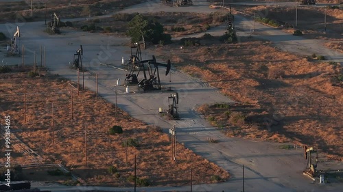 Aerial view of the oil rigs and wells in the Midway-Sunset shale oil fields, the largest in California. A pumpjack operates at an oil field. Oil pump rig energy industrial machine for petroleum.