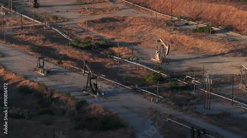 Aerial view of the oil rigs and wells in the Midway-Sunset shale oil fields, the largest in California. A pumpjack operates at an oil field. Oil pump rig energy industrial machine for petroleum.
