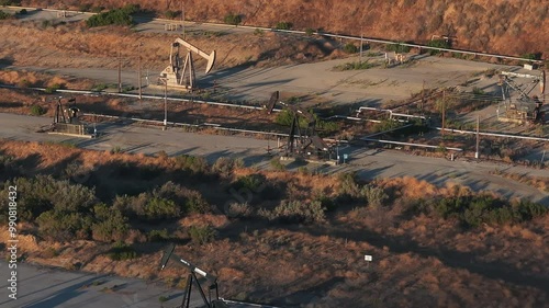 Aerial view of the oil rigs and wells in the Midway-Sunset shale oil fields, the largest in California. A pumpjack operates at an oil field. Oil pump rig energy industrial machine for petroleum.