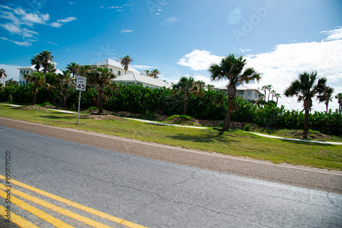 Speed limit 45mph in upscale residential neighborhood beach houses along State Park Road 100, Ocean boulevard near downtown South Padre Island, multistory white painted mansion homes, palm trees