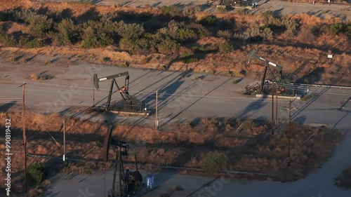 Aerial view of the oil rigs and wells in the Midway-Sunset shale oil fields, the largest in California. A pumpjack operates at an oil field. Oil pump rig energy industrial machine for petroleum.