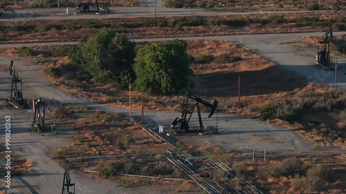 Aerial view of the oil rigs and wells in the Midway-Sunset shale oil fields, the largest in California. A pumpjack operates at an oil field. Oil pump rig energy industrial machine for petroleum.