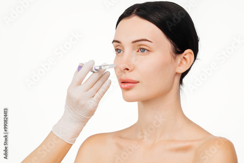 A doctor's hands holding a syringe near a woman's face as she receives a skin lifting injection. This moment emphasizes beauty and modern skincare techniques for a radiant appearance.