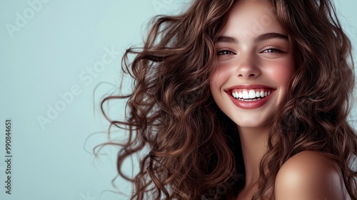 Gorgeous brunette model with long, curly hair who laughs a lot. woman with wavy curls and a smile. A portrait of fashion, beauty, and makeup