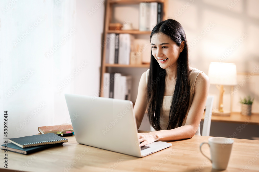 Young happy cheerful cute beautiful woman sit indoors in home office with laptop computer Young happy cheerful cute beautiful woman sit indoors in home office with laptop computer