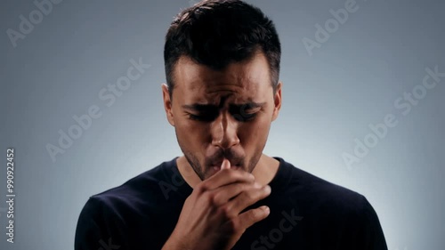 Static studio video, key light, close-up of young man with facial scar expressing nervousness evolving into pride.