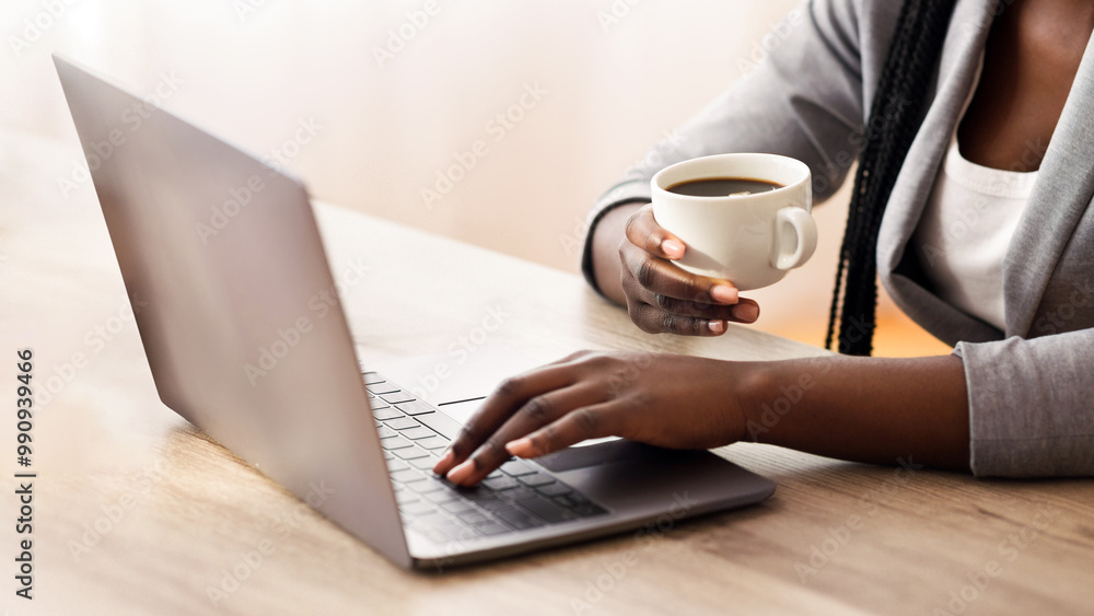 Business lifestyle. Unrecognizable afro female entrepreneur working on laptop and drinking coffee in office, crop Business lifestyle. Unrecognizable afro female entrepreneur working on laptop and drinking coffee in office, crop