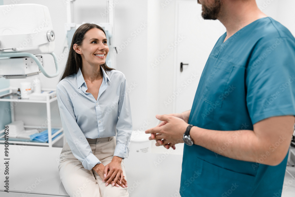 A young male doctor radiologist consults talks to a female patient young woman in a modern medical private clinic before X-ray computed tomography procedure. Healthcare and medicine A young male doctor radiologist consults talks to a female patient young woman in a modern medical private clinic before X-ray computed tomography procedure. Healthcare and medicine