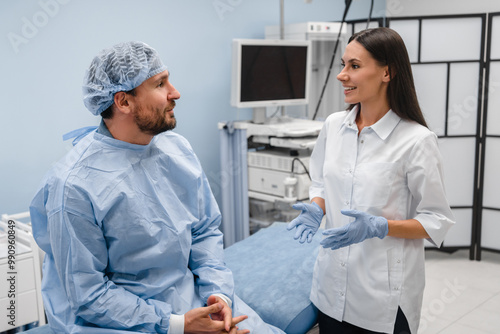 A young female doctor gastroenterologist consults talks to male patient man in a modern medical private clinic cabinet before gastroduodenoscopy procedure. Gastroscopy endoscopy concept