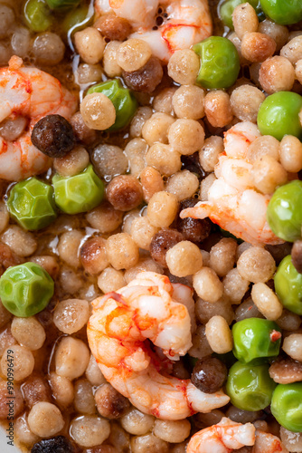 Fregula sarda con pisellini e gamberi, pasta italiana, ricetta mediterranea  photo