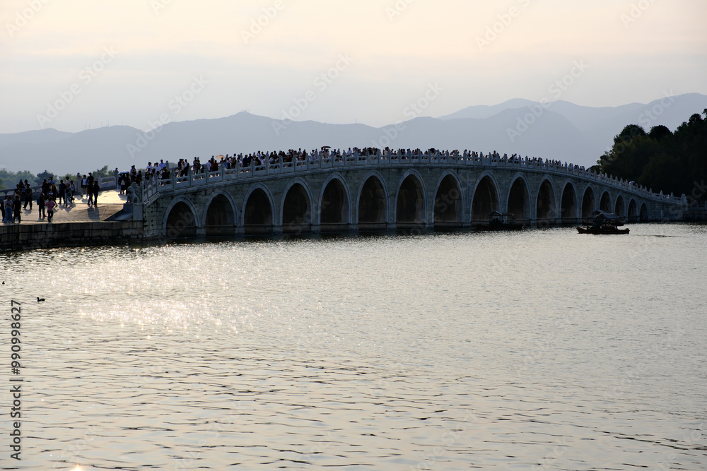 Fototapeta premium Seventeen-Arch Bridge with many tourists in Summer Palace in Beijing, China 