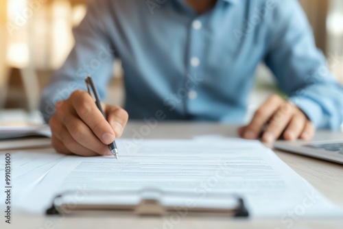 A focused individual signing documents on a desk, illustrating professionalism and productivity in a modern workspace.