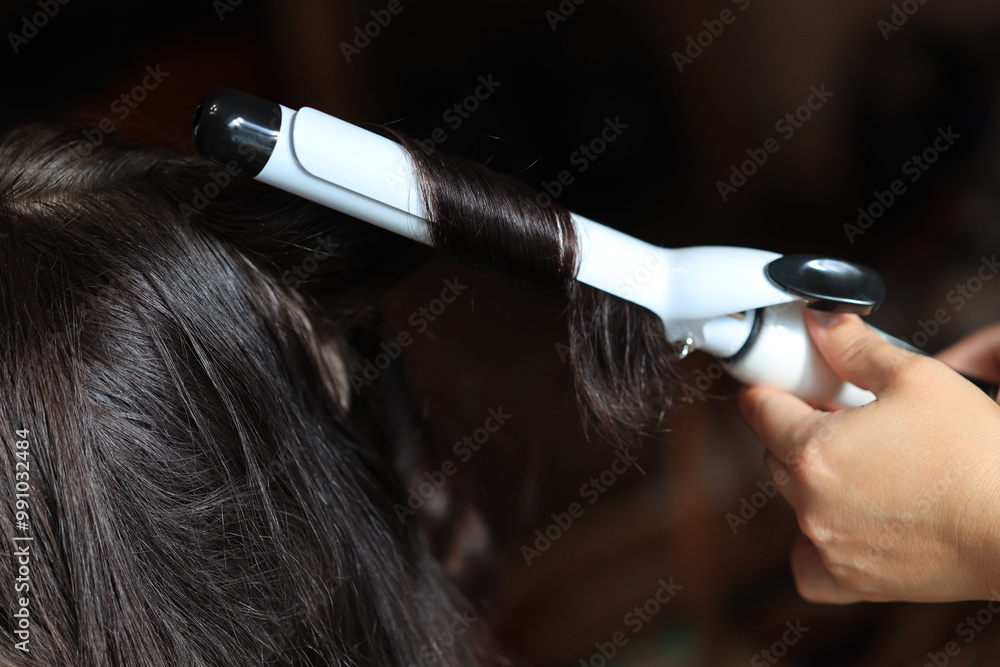 Fototapeta premium A person using a hair dryer to style their hair at home
